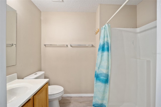 bathroom featuring walk in shower, toilet, hardwood / wood-style flooring, vanity, and a textured ceiling