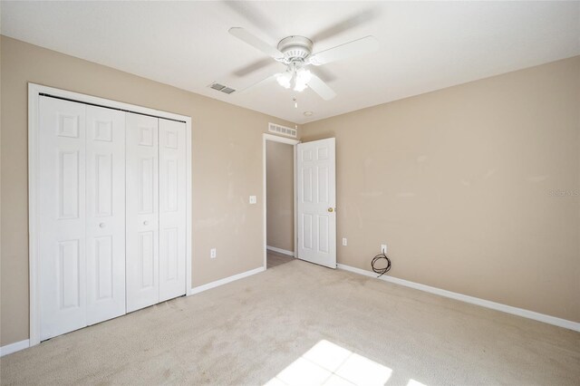 unfurnished bedroom featuring ceiling fan, a closet, and light carpet