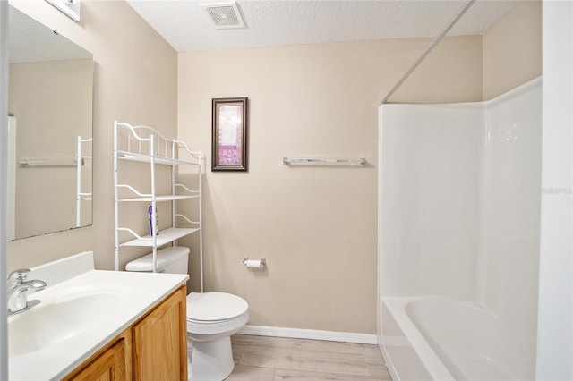 full bathroom featuring vanity, bathtub / shower combination, a textured ceiling, hardwood / wood-style flooring, and toilet