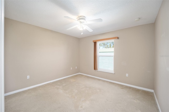 carpeted empty room featuring ceiling fan and a textured ceiling