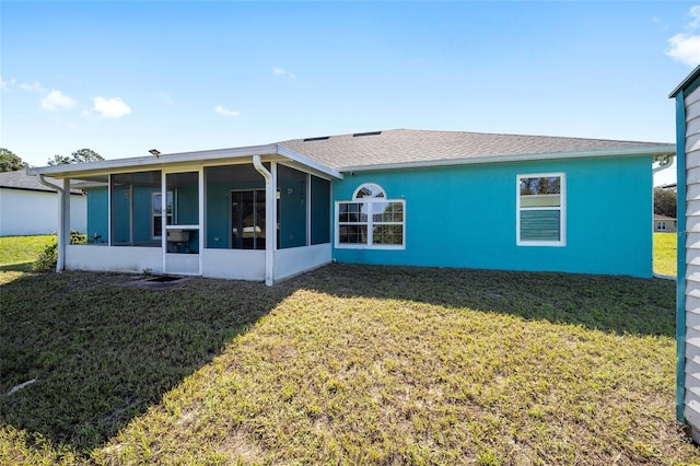 rear view of house featuring a sunroom and a yard