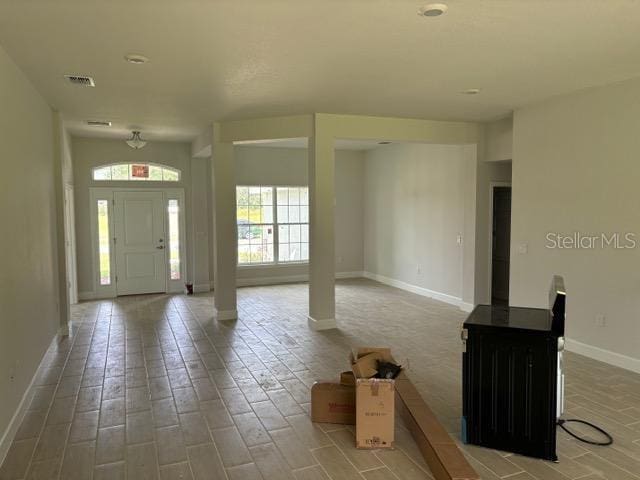 entryway with baseboards, wood finished floors, and visible vents