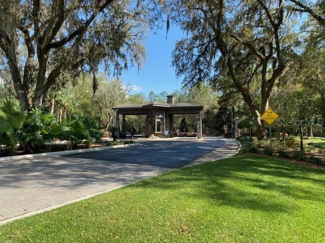 view of property's community featuring driveway and a yard