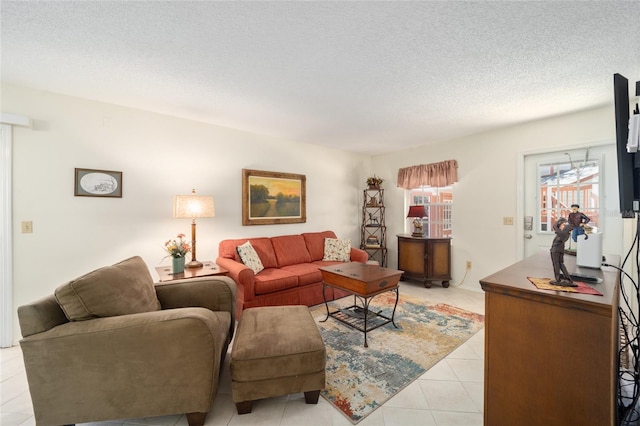 living room with a textured ceiling and light tile patterned flooring