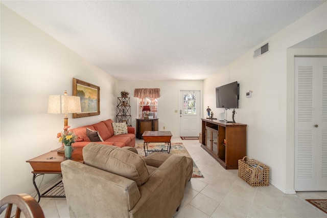 tiled living room featuring a textured ceiling