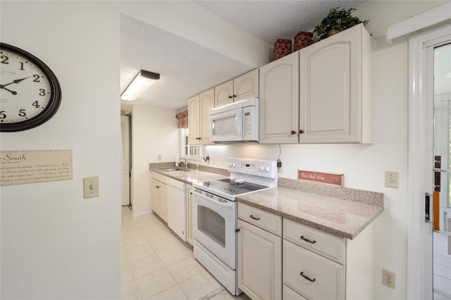 kitchen featuring light tile patterned flooring, white appliances, sink, and a textured ceiling