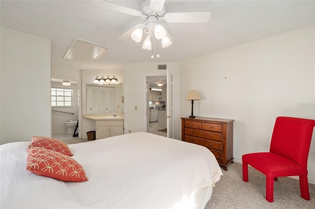 bedroom featuring ensuite bathroom, ceiling fan, and light carpet