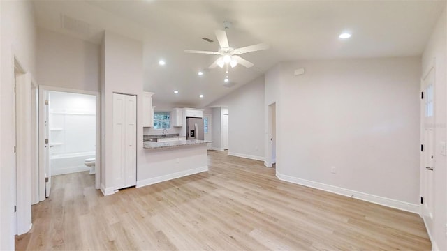 interior space with ceiling fan, light hardwood / wood-style floors, and high vaulted ceiling