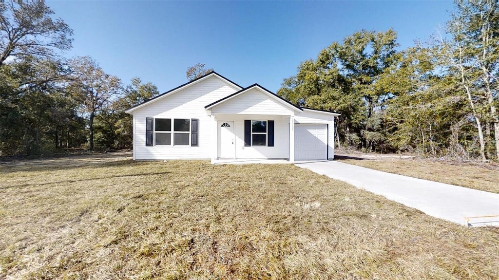 view of front of home with a front yard and a garage