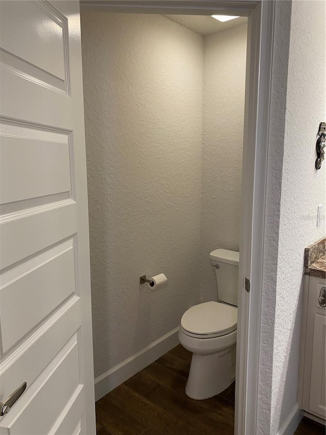 bathroom with toilet and hardwood / wood-style floors