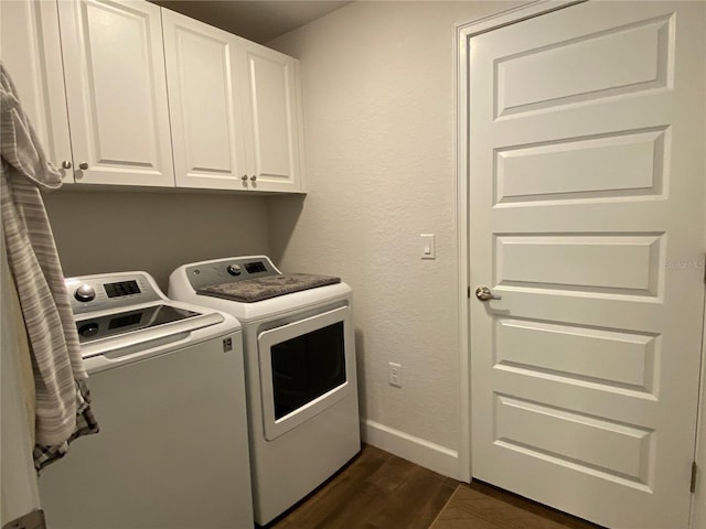 washroom featuring cabinets, washing machine and dryer, and dark hardwood / wood-style floors