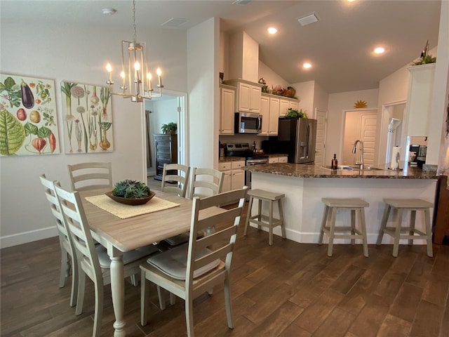 dining area featuring high vaulted ceiling, dark hardwood / wood-style floors, sink, and a notable chandelier