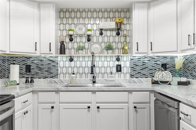 kitchen featuring white cabinets, light stone counters, backsplash, sink, and stainless steel appliances