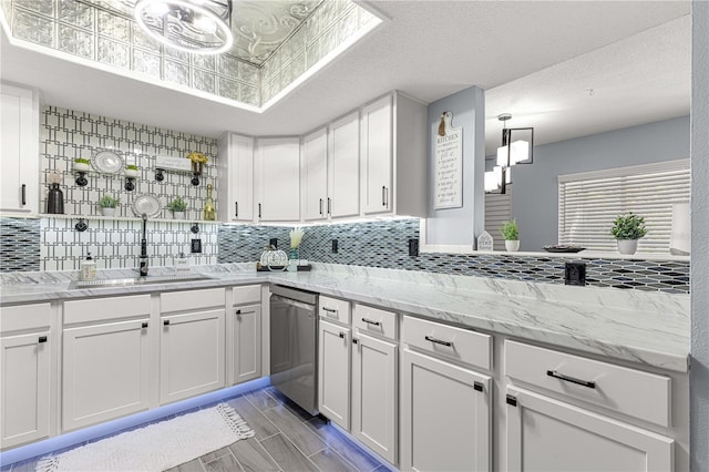 551 Fairways Dr Unit A, Ocala, FL 34472 - kitchen with a sink, decorative backsplash, light stone counters, stainless steel dishwasher, and white cabinets