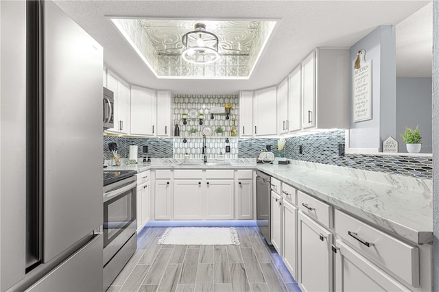 kitchen featuring appliances with stainless steel finishes, white cabinets, and sink