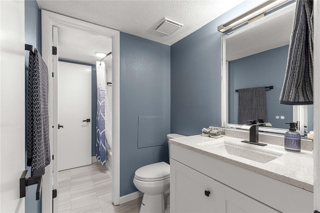 bathroom featuring vanity, a textured ceiling, toilet, and walk in shower