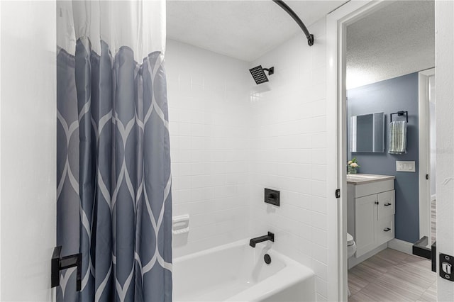 full bathroom featuring vanity, shower / bath combo with shower curtain, a textured ceiling, and toilet