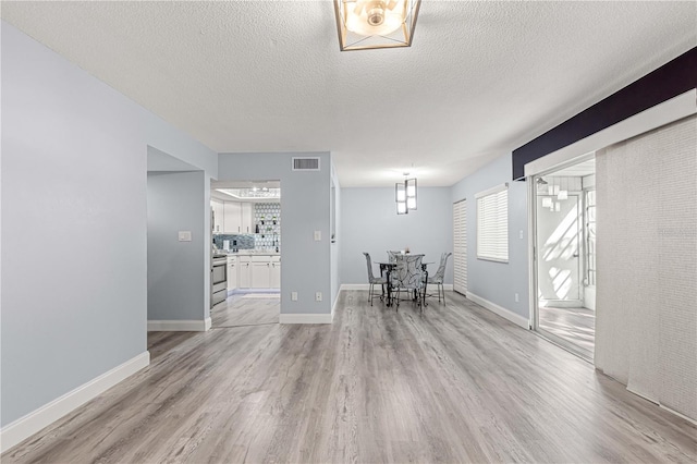 551 Fairways Dr Unit A, Ocala, FL 34472 - living area with a textured ceiling, visible vents, light wood-style flooring, and a healthy amount of sunlight