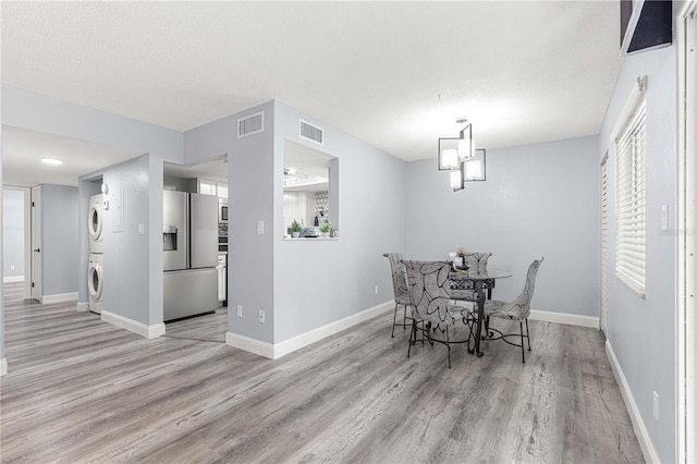 551 Fairways Dr Unit A, Ocala, FL 34472 - dining area featuring stacked washer and clothes dryer, baseboards, visible vents, and light wood-style floors