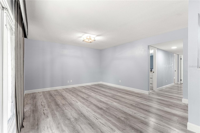 spare room with light hardwood / wood-style flooring and a textured ceiling