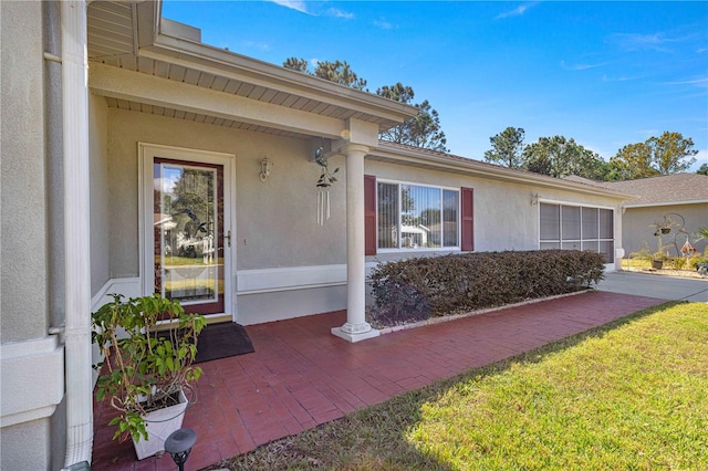 entrance to property with a lawn