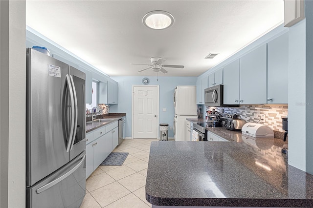 kitchen featuring blue cabinets, appliances with stainless steel finishes, kitchen peninsula, and ceiling fan