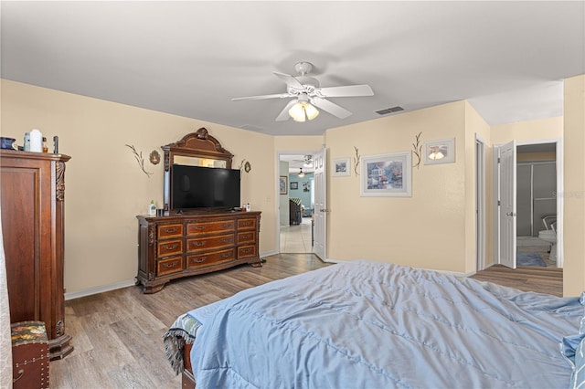 bedroom featuring connected bathroom, ceiling fan, and light wood-type flooring