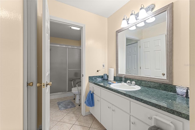 bathroom featuring toilet, a shower with shower door, vanity, and tile patterned floors