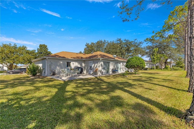 back of property featuring a yard and a patio area