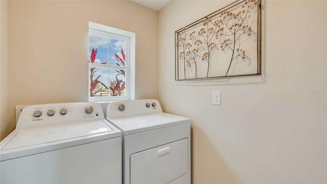 clothes washing area featuring washing machine and clothes dryer and a wealth of natural light