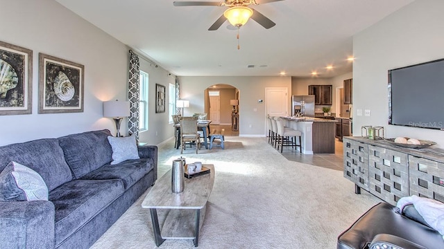 carpeted living room with ceiling fan