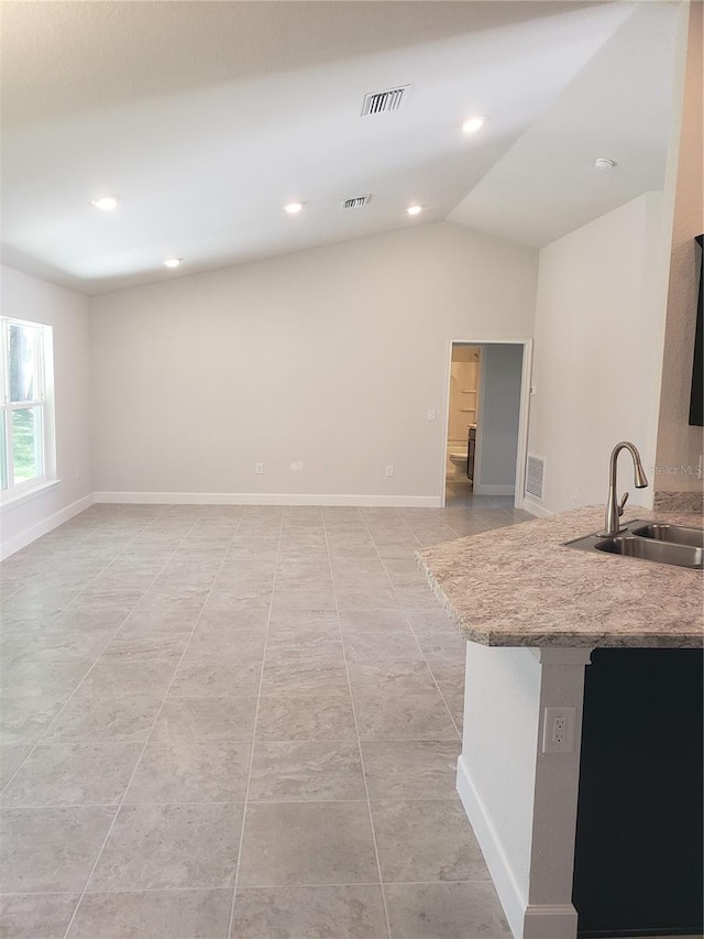 kitchen with visible vents, vaulted ceiling, and a sink