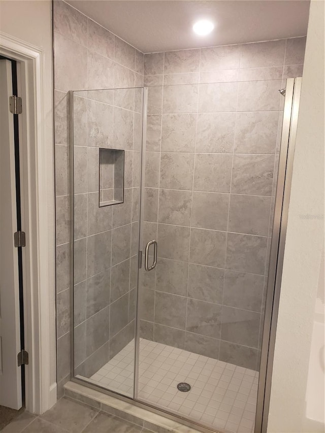 bathroom with a stall shower and tile patterned floors