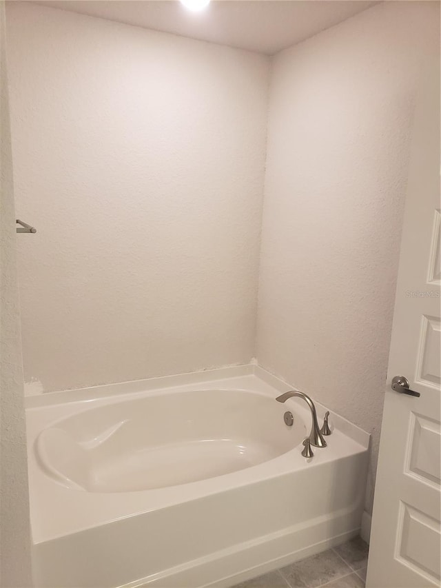 bathroom with tile patterned flooring and a garden tub