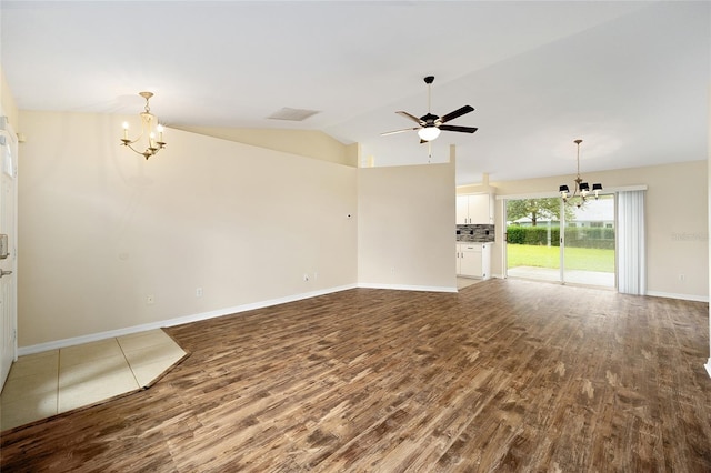 unfurnished living room with wood-type flooring, ceiling fan with notable chandelier, and vaulted ceiling