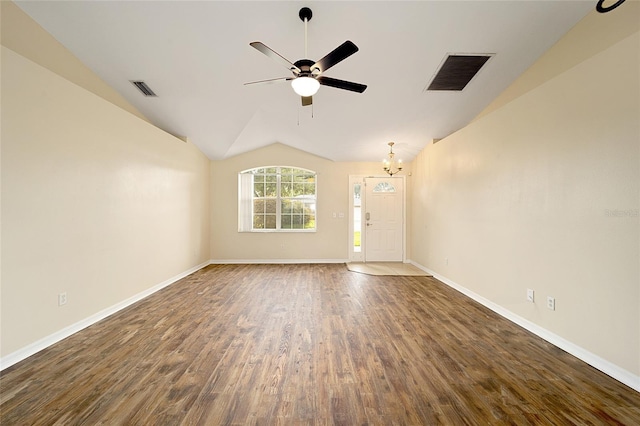 unfurnished room featuring lofted ceiling, ceiling fan with notable chandelier, and dark hardwood / wood-style flooring