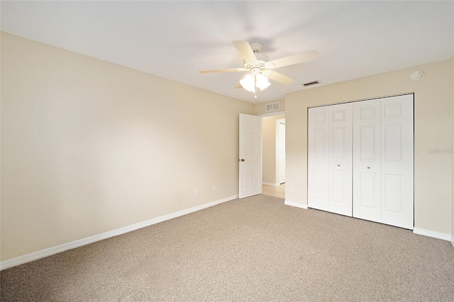 unfurnished bedroom featuring ceiling fan, a closet, and carpet