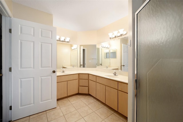 bathroom with a shower with door, tile patterned floors, and vanity