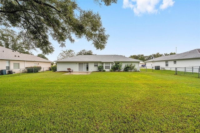 back of house featuring a lawn and a patio area