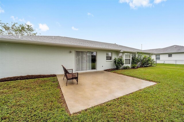 rear view of property featuring a patio and a lawn