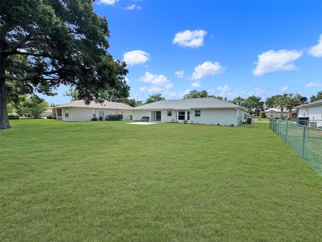 back of property with a lawn and fence private yard