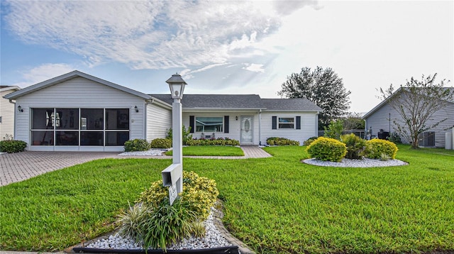 ranch-style home featuring a sunroom and a front lawn