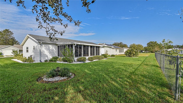 back of property featuring a sunroom and a yard