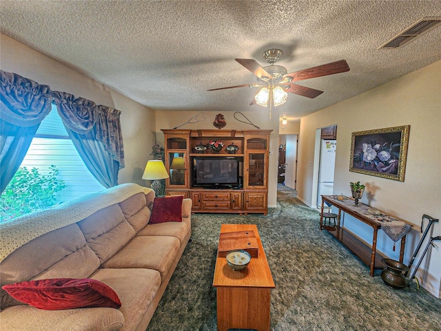 carpeted living room featuring ceiling fan and a textured ceiling