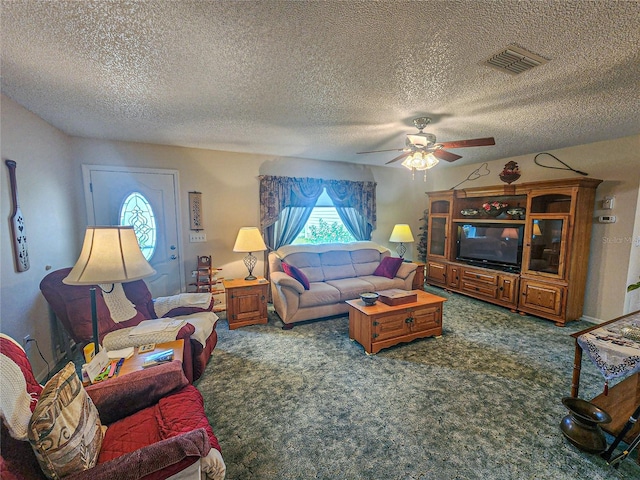 living room with ceiling fan, carpet, and a textured ceiling