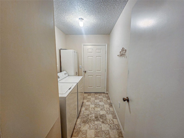 washroom with separate washer and dryer and a textured ceiling