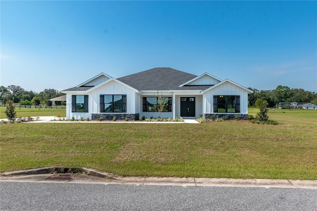 2073 NW 79th Loop, Ocala, FL 34475 - modern inspired farmhouse with a front yard, a shingled roof, and board and batten siding