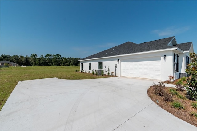2073 NW 79th Loop, Ocala, FL 34475 - view of side of property with driveway, a yard, a garage, stucco siding, and central AC