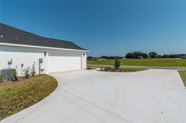 view of property exterior featuring a garage, a lawn, and central AC unit