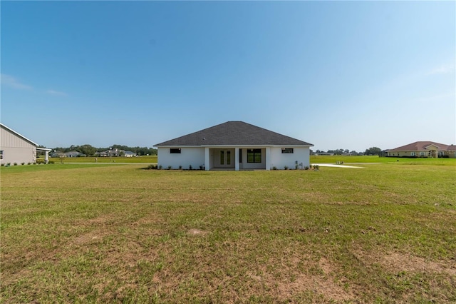 rear view of property featuring a yard